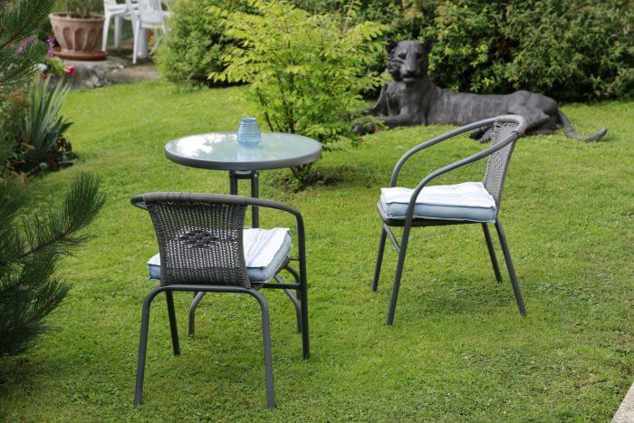 Lauschige Sitzecke im Garten mit Tisch und Stühlen auf der Wiese