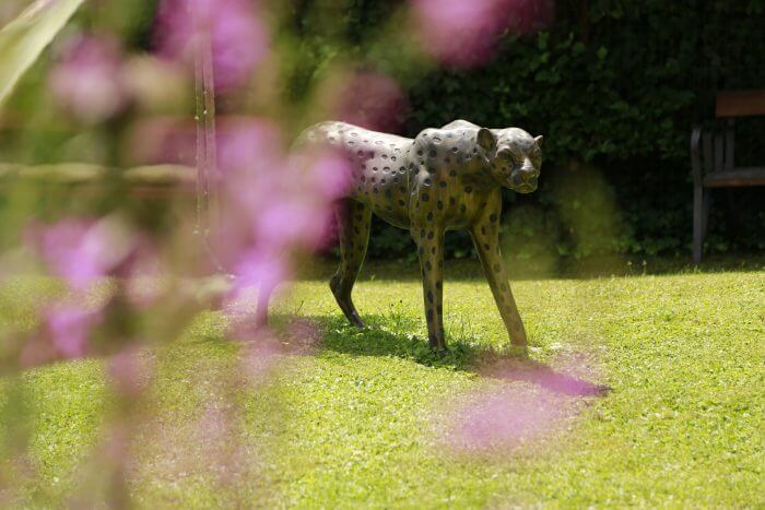 Gartenskulptur zwischen blühenden Sträuchern im Garten des Hauses Feuchtl